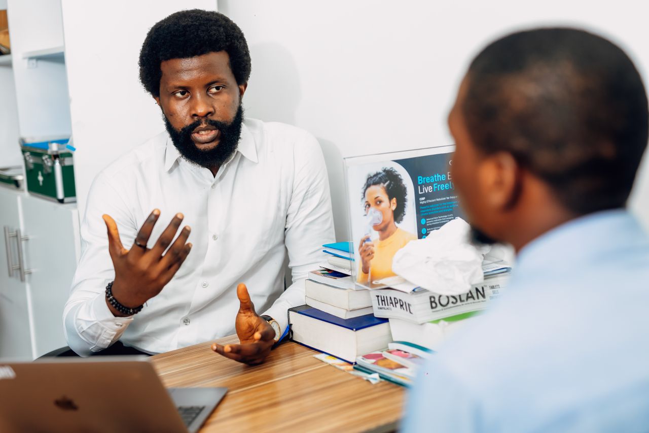 Mon offre A doctor discusses health concerns with a patient at a medical office in Lagos, Nigeria.