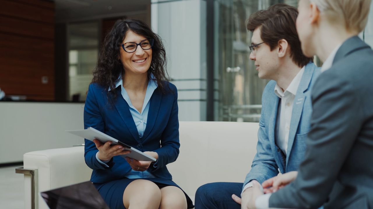 Mon offre Professionals discussing business strategy in a corporate office setting.